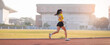 © EduLife Photos - A young Asian woman athlete runner jogging on running track in city stadium in the sunny morning to keep fitness and healthy lifestyle. Young fitness woman runs on stadium track. Sport and recreation