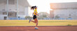 © EduLife Photos - A young Asian woman athlete runner jogging on running track in city stadium in the sunny morning to keep fitness and healthy lifestyle. Young fitness woman runs on stadium track. Sport and recreation