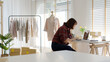 © ChayTee - Young asia freelance seller woman happy typing check on laptop computer busy at home office desk use digital tablet in fashion studio SME online store social e-commerce sale page service web support.