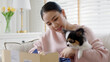 © ChayTee - Young happy asia people girl smile enjoy with cute dog unbox snack food post mail sit relax at home comfort sofa couch in omni channel fast send parcel via online sale pet shop store e-commerce order.
