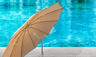 parasol sur plage de piscine bleue 