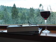Kieliszek czerwonego wina i książka na tle okna