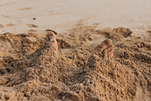 Close Up Of Toes Sticking Out Of The Sand On A Beach On Oahu