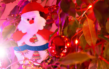 Christmas tree decoration. Santa Claus hanging between balls and Christmas lights. Selective focus. Background. Banner.