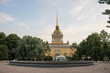 Saint PETERSBURG, RUSSIA-JULY, 15, 2021: Yellow Admiralty building with a golden spire next to green trees in the early summer morning