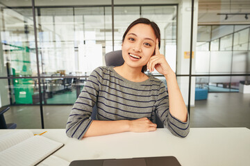 Friendly woman at her desk with notebook and computer