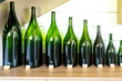 Different types of green glass champagne sparkling wine bottles from smallest to biggest