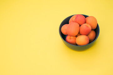 Sticker - Bowl of fresh apricots isolated on yellow background with copy space