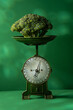 Head of broccoli on a vintage scale against green background