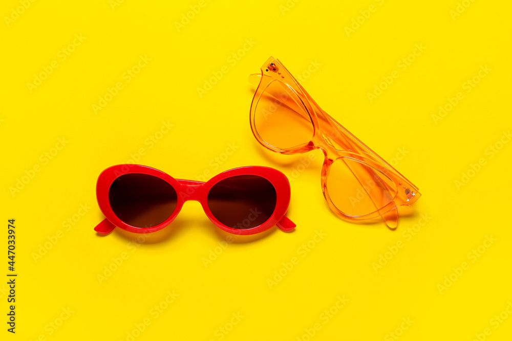 Stylish sunglasses on color background