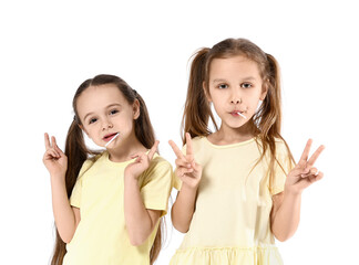 Sticker - Cute little sisters eating lollipops on white background