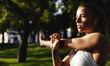 © Liubov Levytska - Young woman with fit body prepare for run, stretching arm and looking away, workout in city park Female model in sportswear exercising outdoors. Athlete girl jogging