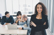 © Danai - Portrait of cheerful confident businesswoman arms crossed smiling in modern office