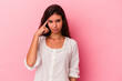 © Asier - Young caucasian woman isolated on pink background pointing temple with finger, thinking, focused on a task.
