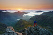 Unrecognizable Tourist taking in a sunrise view over the three sisters mountains, Glencoe, Highlands, Scotland.
