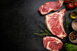 © petrrgoskov - Variety of Fresh Raw Black Angus Prime Meat Steaks T-bone, New York, Ribeye and seasoning on black background, top view