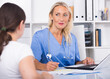 © JackF - Portrait of mature female doctor listening to patient complaints at clinic