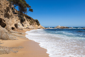 Cala estreta in Palamos, Costa Brava, Spain, sandy beach with sea and rocky mountain