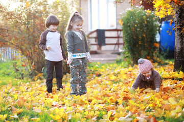 Young family on a walk in the autumn park on a sunny day. Happiness to be together.