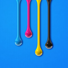 Wall Mural - cmyk ink drops on blue paper square background