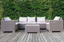 Beautiful Wooden Terrace With Rattan Garden Furniture With Greenery Background.
