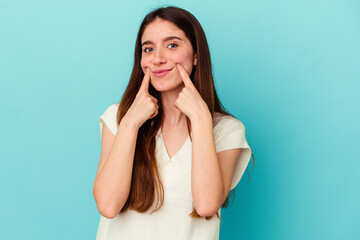 Young caucasian woman isolated on blue background doubting between two options.