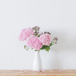 © Maya Kruchancova - pink   hydrangea in white vase on wooden shelf  on background white wall