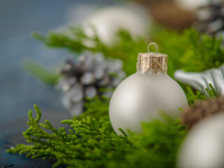 Wall Mural - A very beautiful composition. Symbolizes Christmas, New Year. Associated with magic, magic, fairy tale. Silver-colored Christmas ball, coniferous branches and cones on a dark blue background.