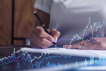 Wall Mural - A client in casual wear is signing the contract to invest money in stock market. Internet trading and wealth management. Forex and financial hologram chart over the desk. Women in business concept.