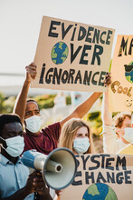 Young Multiracial Demonstrators Protesting For Climate Change Wearing Protective Masks Outdoor In The City - Focus On Center Man Face