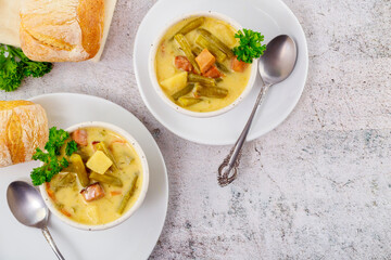 Wall Mural - Homemade vegetable soup with cut green peas, potato and meat.