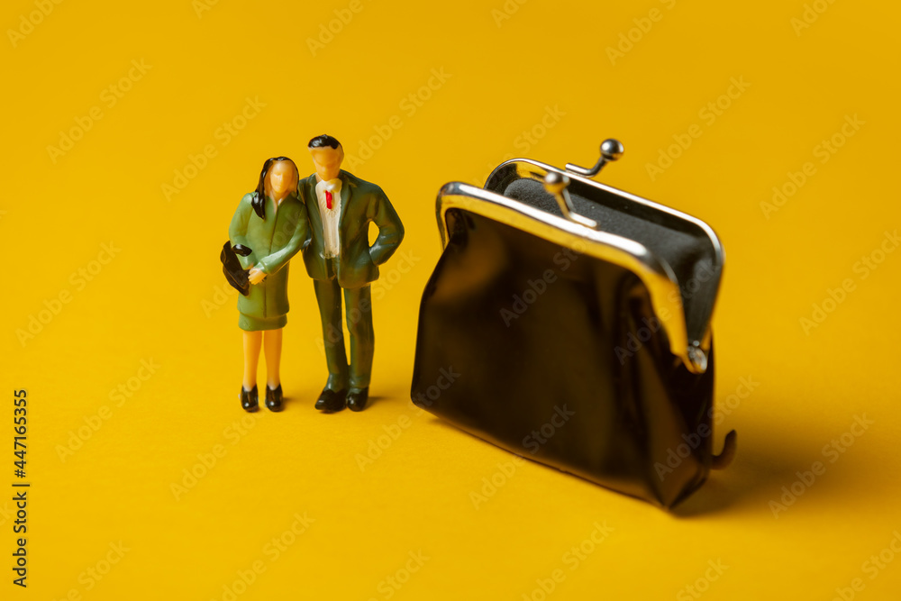 miniature figures of a man and woman next to classic wallet on yellow background - obrazy, fototapety, plakaty 