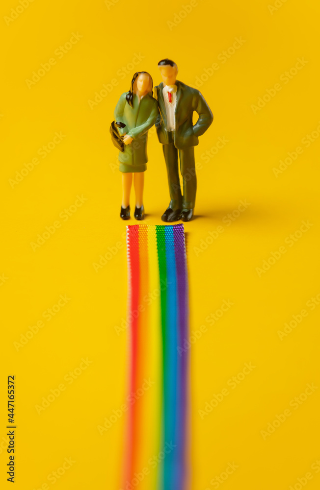Woman and man stands face on rainbow path - obrazy, fototapety, plakaty 