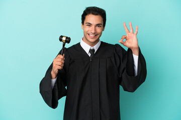 Wall Mural - Judge over isolated blue background showing ok sign with fingers