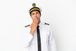© luismolinero - Airplane pilot over isolated white background yawning and covering wide open mouth with hand
