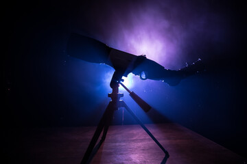 Wall Mural - silhouette of a astronomy telescope on dark foggy backlight.