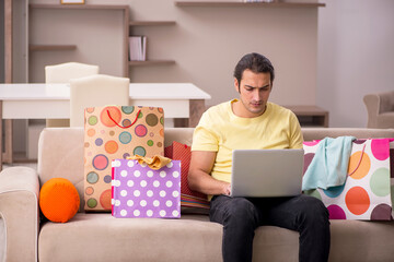 Canvas Print - Young man ordering giftboxes via Internet