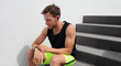 © Maridav - Smartwatch using man connecting to wireless earphones to listen to music during run workout. Athlete runner with wearable technology sports watch at fitness gym.