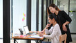 © Prathankarnpap - Two female colleagues using smart phone together during break in office.