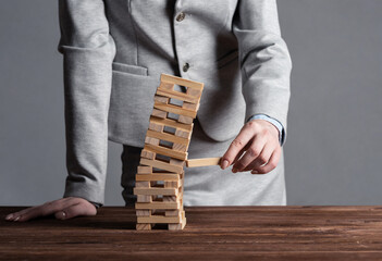 Wall Mural - Businesswoman removing wooden block from tower