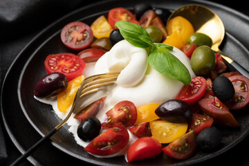 Burrata cheese with tomatoes and olives. Caprese salad with mozzarella 