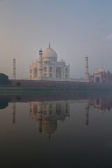 Wall Mural - View of Taj Mahal with early morning fog reflected in Yamuna River, Agra, Uttar Pradesh, India