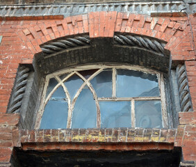 Wall Mural - One arched glass window on old red brick wall. 