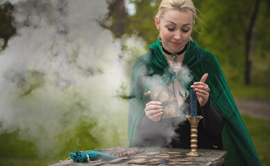 Wall Mural - Magical ritual with a candle and spell in forest. Witchcraft and esoteric concept. Wicca or paganism