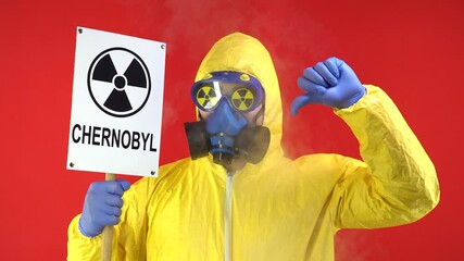 Wall Mural - Man in Protective Chemical Suit, Mask and Banner in Hands. Chernobyl Shows Thumb Down. Smoke Around Man. Protection Concept, Radioactive Hazard Concept. Red background, Isolate, Studio Footage, 4k