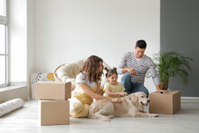 Happy Family With Dog And Moving Boxes In Their New House