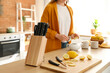 Stand with knives and lemon on table in kitchen