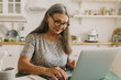 © shurkin_son - Inspired older woman typing on laptop. Elderly smiling lady composing story on device, work from home. Hobby for soul, creativity, inspiration, technology concept