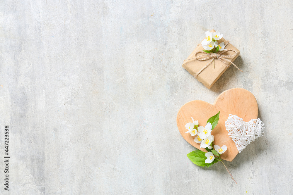 Composition with gift box and beautiful jasmine flowers on light background