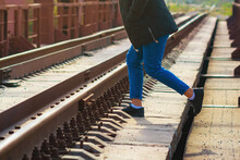 A Woman Steps Over The Rails In An Unidentified Place For Passage